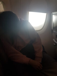 Schlafende Frau im Emirates Flugzeug am Fenster