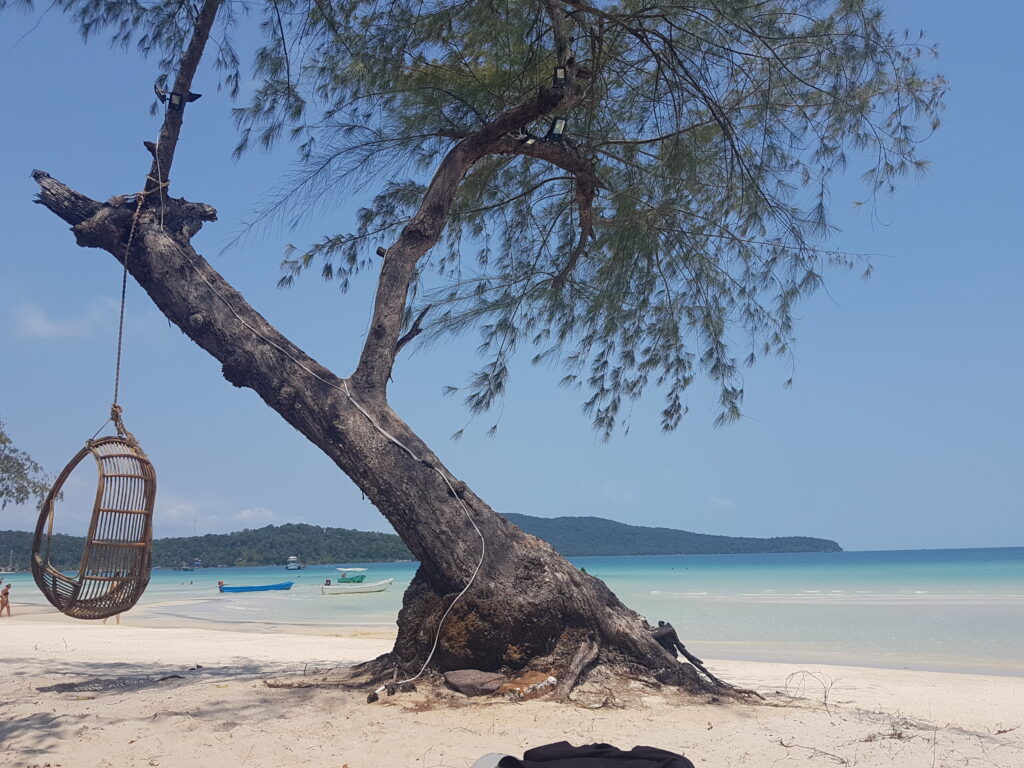 Strand mit Schaukel und weißem Sand und türkisfarbenem Wasser