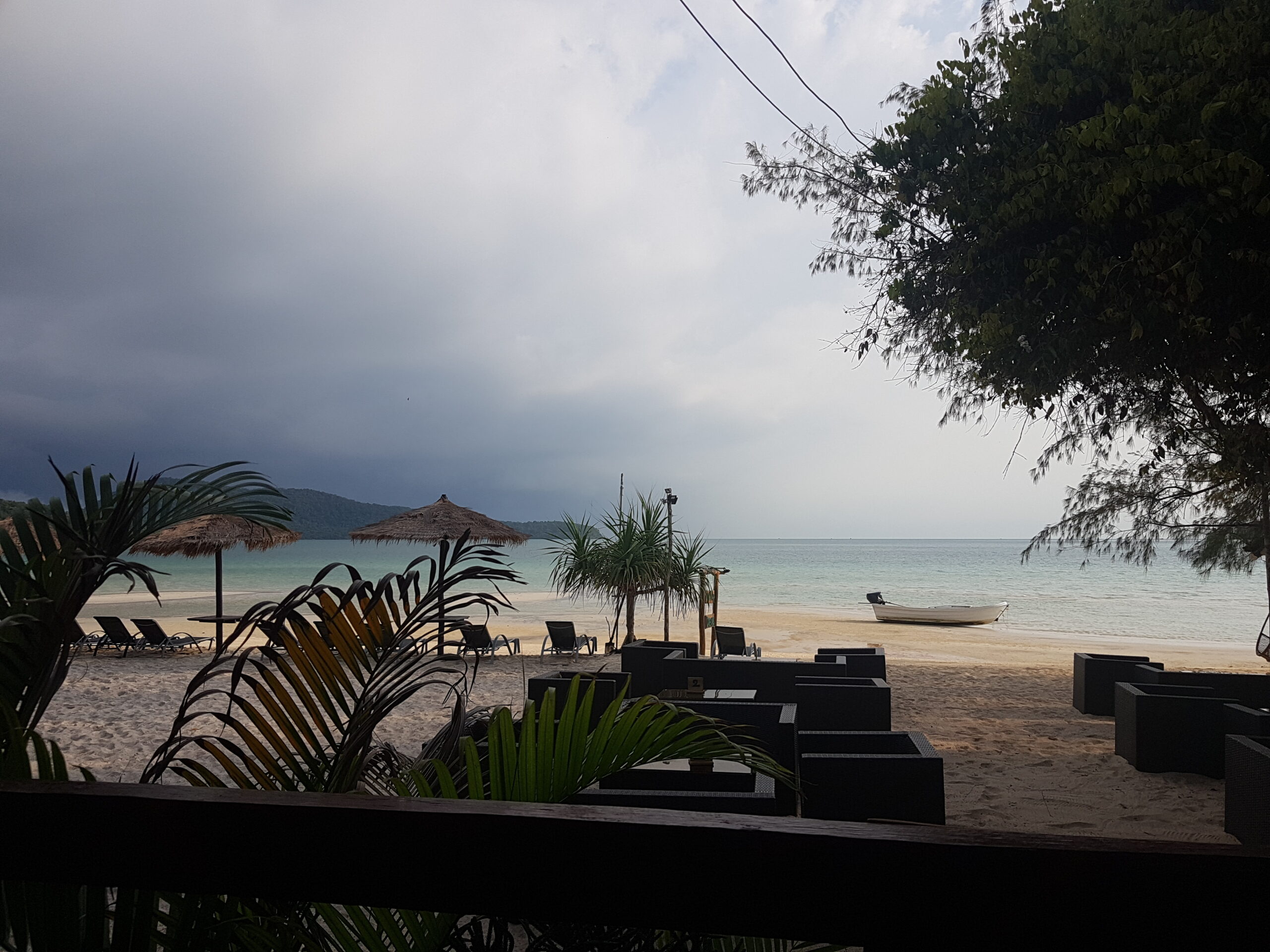 Dunkle Wolken über einer Insel mit Meer.